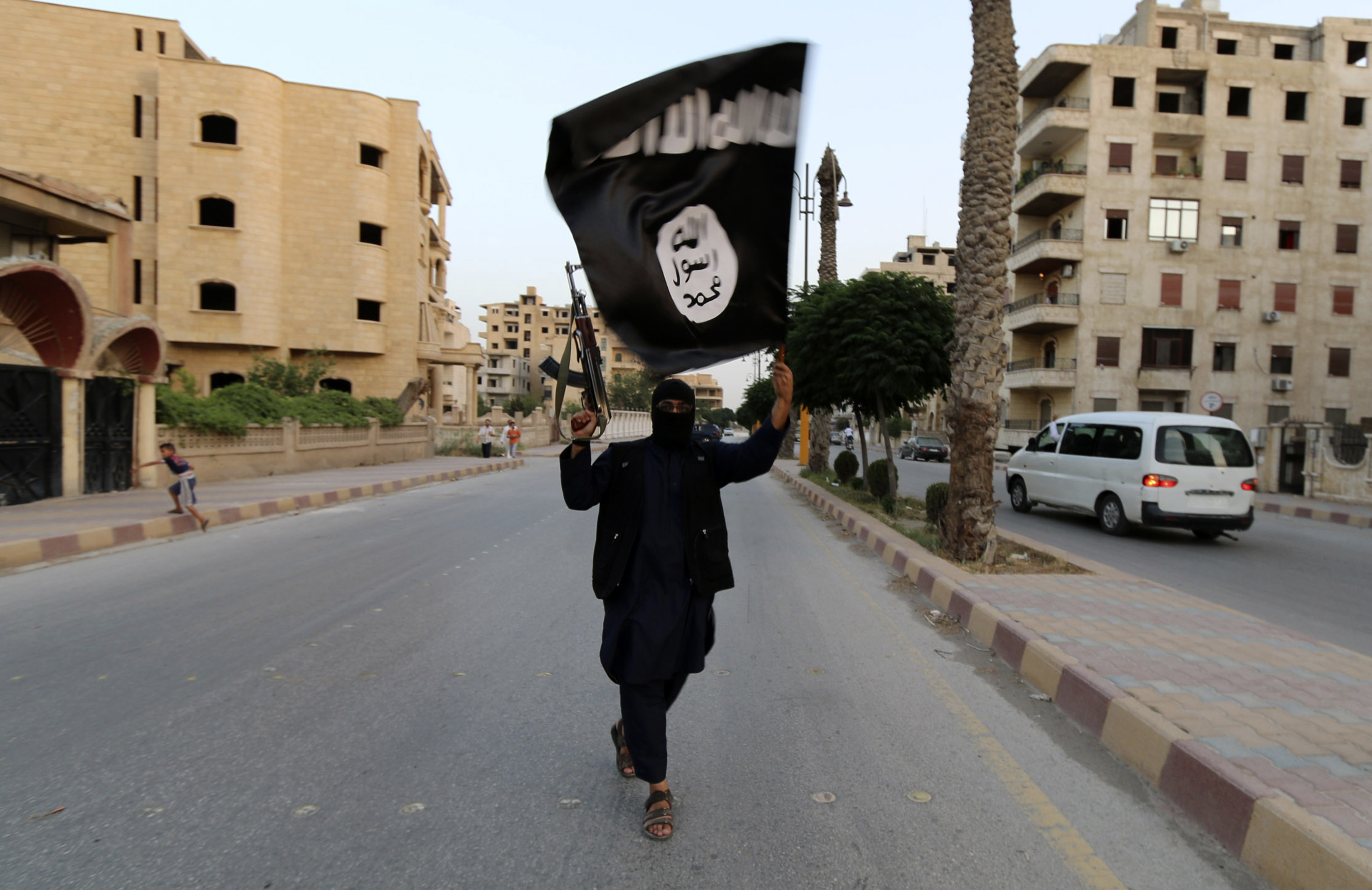 A member loyal to the Islamic State in Iraq and the Levant (ISIL) waves an ISIL flag in Raqqa June 29, 2014. The offshoot of al Qaeda which has captured swathes of territory in Iraq and Syria has declared itself an Islamic "Caliphate" and called on factions worldwide to pledge their allegiance, a statement posted on jihadist websites said on Sunday. The group, previously known as the Islamic State in Iraq and the Levant (ISIL), also known as ISIS, has renamed itself "Islamic State" and proclaimed its leader Abu Bakr al-Baghadi as "Caliph" - the head of the state, the statement said. REUTERS/Stringer (SYRIA - Tags: POLITICS CIVIL UNREST TPX IMAGES OF THE DAY)  FOR BEST QUALITY IMAGE ALSO SEE: GF2EAAO0VU501 - RTR3WBPT